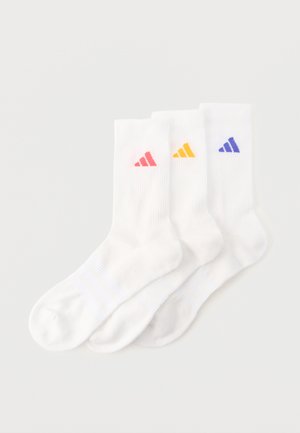 Drei weiße Crew-Socken mit gerippter Struktur, jede mit einem kleinen dreieckigen Logo in Rot, Gelb und Blau am Knöchel.