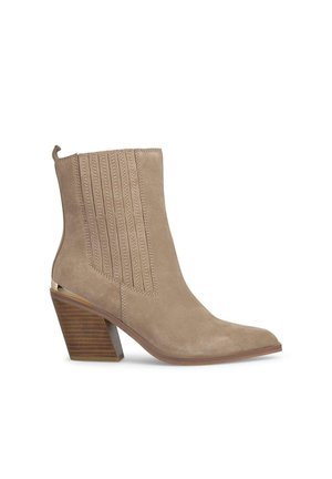 Stivale alla caviglia in suede beige con cuciture verticali, punta affusolata e tacco in legno impilato. Presenta una linguetta per una vestibilità più semplice.