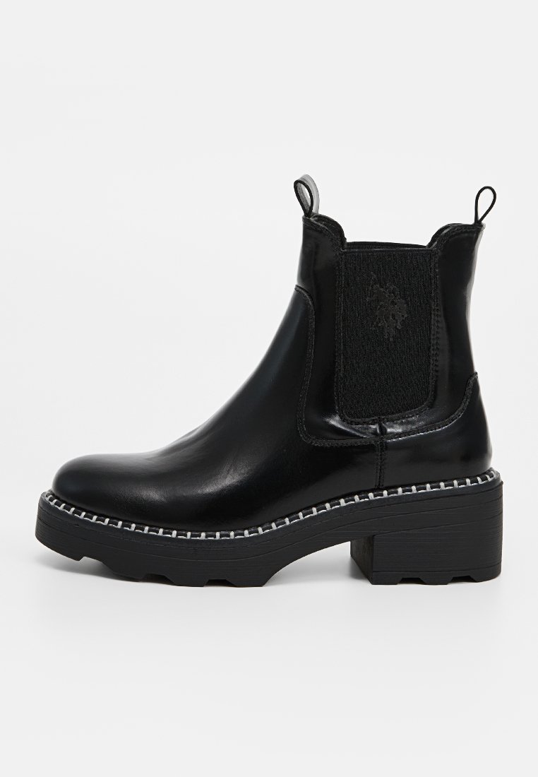 Bottines en cuir noir avec des panneaux élastiques sur les côtés, un talon bloc et des coutures blanches contrastantes le long de la semelle. Texture lisse et bout arrondi.