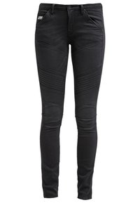 Jeans ajustados negros de mezclilla, con acentos acanalados en las caderas y en las rodillas, con una textura suave y un diseño clásico de cinco bolsillos.