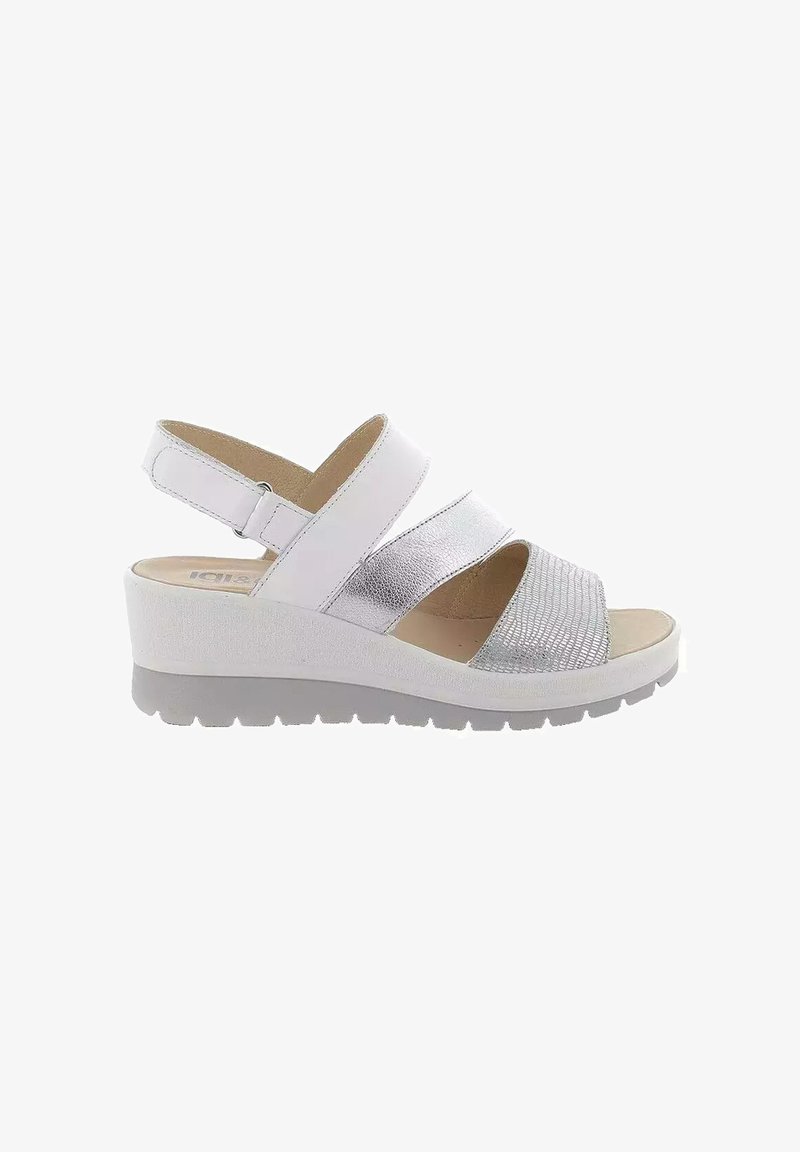 Sandalo con zeppa bianca e accenti metallici argento, caratterizzato da tre fasce larghe e una soletta imbottita. Dettaglio in tessuto texturizzato sulle fasce.
