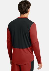 Langärmliges Sporthemd mit einem Farbblockdesign in Rot und Schwarz, aus glattem, leichtem Stoff und mit dehnbarem Schnitt.