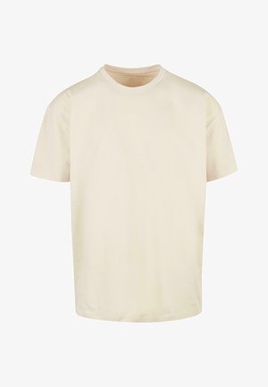 Kremowa bawełniana koszulka z okrągłym dekoltem, krótkimi rękawami i luźnym krojem. Materiał jest miękki o gładkiej teksturze; brak wzorów lub akcentów.