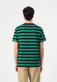 Vihreä ja tummansininen raidallinen lyhythihainen T-paita, puuvillamateriaalia, pyöreä pääntie, rento malli, näkyvät saumat ja sileä takaosa.