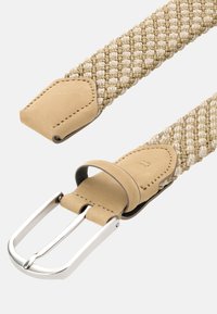 Ljust beige vävt tygbälte med en silverfärgad metallspänne och matchande beige lädertrim på båda ändarna och där spännet fästs.