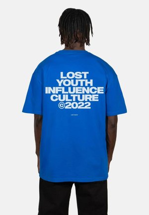 Blå bomulds T-shirt med korte ærmer; har fed hvid tekst på ryggen, der siger "LOST YOUTH INFLUENCE CULTURE ©2022." Simpelt design.