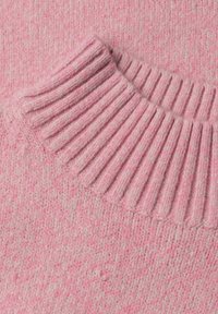 Gros plan d'un tissu tricoté rose montrant un col côtelé plié avec une texture douce et duveteuse.