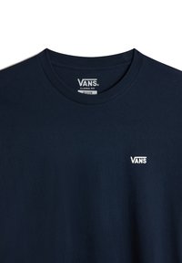 Námorně modré bavlněné tričko s klasickým střihem. Má kulatý výstřih a malé bílé logo "VANS" na levé části hrudi. Měkká textura.