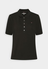 Schwarzes Poloshirt mit Kragen, kurzen Ärmeln und einer Dreiknopfleiste. Kleines gesticktes Logo auf der linken Brust. Weicher Baumwollstoff.