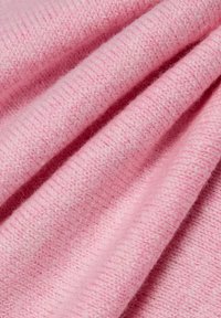 Weiches rosa Strickgewebe mit glatter Textur, das ein dichtes Muster aus verflochtenen Garnen und ein leicht erhöhtes Rippendetail aufweist.