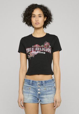 T-shirt nera corta con scritta "True Religion", decorata con motivi floreali colorati. Abbinata a pantaloncini di denim a vita alta azzurri.