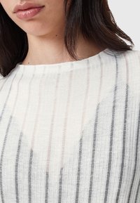 Top in tessuto leggero con motivo a righe verticali in bianco, grigio e delicate tonalità pastello. Presenta un colletto rotondo e una finitura testurizzata.