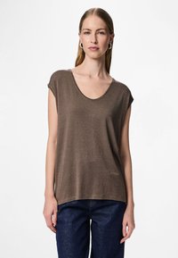 Ruskea lyhythihainen paita, jossa leveä pyöreä pääntie, valmistettu teksturoidusta kankaasta, jossa on hienostunut hohto, yhdistetty tummansinisiin farkkuihin.