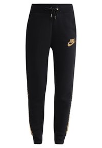 Svarta sweatpants med dragsko i midjan, guld Nike-logga och dekorativa guldaccenturer längs sidorna. Tillverkade av mjukt, texturerat tyg.