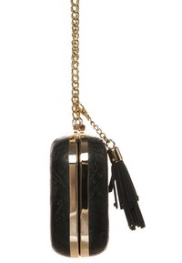 Clutch nera con motivo in rilievo, hardware dorato e tracolla a catena. Presenta un dettaglio con nappina sul lato. Forma rettangolare.