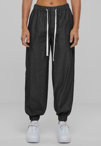 Dark gray jogger pants with an elastic waistband and white drawstring; cuffed at the ankles; made of a soft, lightweight material.