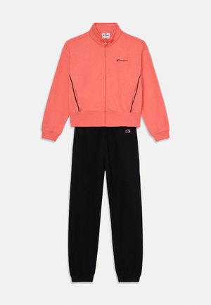 Sweatshirt coral com fecho e detalhes em preto e logótipo; combinado com calças de fato pretas ajustadas com punhos elásticos e detalhe do logótipo.