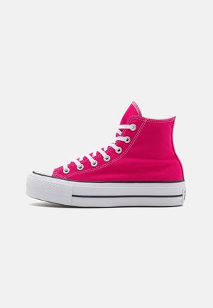 High-top sneakers in bright pink canvas with white laces and rubber sole. Features toe cap and black accent stripe along the sole.