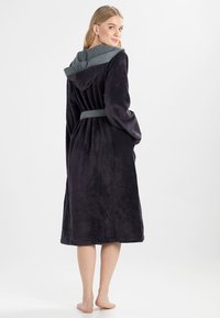 Dark purple fleece bathrobe with a gray hood and belt. Soft texture, mid-calf length, featuring side pockets and a relaxed fit.