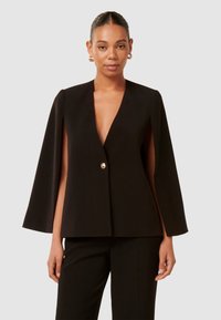 Schwarze Cape-Jacke im Stil mit tiefem V-Ausschnitt und einem einzelnen Knopfdetail. Hergestellt aus glattem Stoff, mit weiten Ärmeln und ohne sichtbare Taschen.