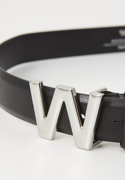 Schwarzer Leder-Gürtel mit einer glänzenden silbernen Metall-Schnalle in Form des Buchstabens "W". Der Gürtel hat eine glatte Textur mit minimaler Naht.