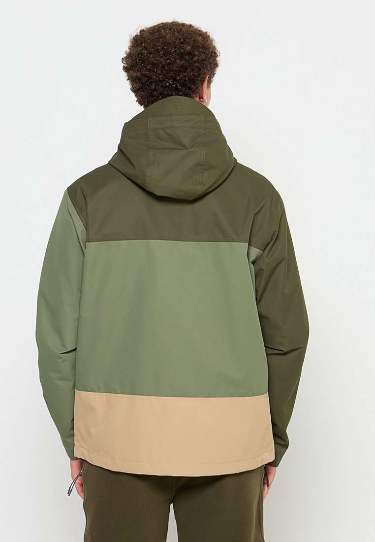 Giacca color-block con sezioni di verde oliva, verde chiaro e beige. Realizzata in tessuto leggero con cappuccio e coulisse regolabile.