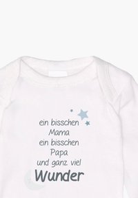 White baby onesie with short sleeves featuring printed text in gray and blue stars, stating familial phrases and the word "Wunder" prominently.
