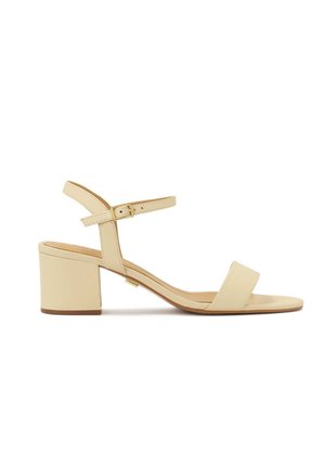 Sandale beige à bout ouvert avec un talon bloc et une bride de cheville réglable avec une petite boucle dorée.