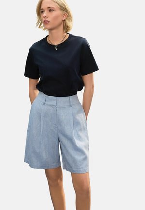 Navy short-sleeve t-shirt paired with light blue, tailored high-waisted shorts featuring side pockets and a subtle texture.