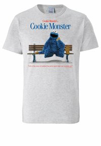 Gray cotton t-shirt featuring Cookie Monster sitting on a bench, holding a cookie. Text includes his name and a quote about cookies.