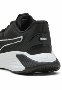 Fekete sportcipő sima szövet felsőrésszel, fehér díszítéssel, texturált sarokpufferral és "PUMA" logóval. ProFoam párnázással rendelkezik.