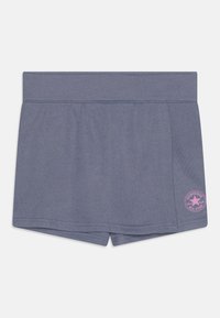 Shorts en coton gris avec une texture douce, dotés d'une taille large et d'un patch logo Converse rose en bas à droite.