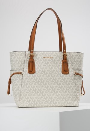Beige og brun Michael Kors tote taske med logomønster, dobbelte brune læderhanke, sidelommer og gulddetaljer.