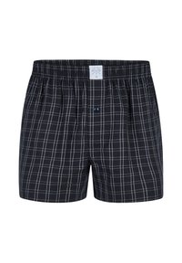 Boxer shorts a scacchi bianco e nero realizzati in cotone, con vita elastica, apertura a bottone singolo e leggere pince laterali.