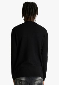 Maglione nero lavorato a maglia con scollo rotondo e maniche lunghe, caratterizzato da una texture liscia e un design semplice, visto da dietro.