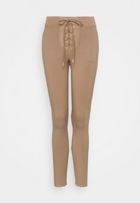 Ljusbruna leggings med en åtsittande design, med en snörning fram, elastisk midja och mjuk textur.