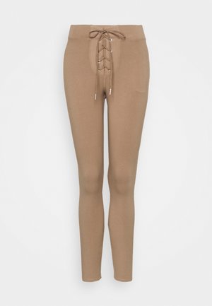 Světle hnědé legíny s těsným střihem, s řasením na přední straně, elastickým pasem a hladkým povrchem.