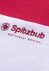 Rot und weißes Sport-T-Shirt mit einem strukturierten Logo "Spitzbub Sportswear Edition" in dunkelrot auf dem Stoff. Einfaches, modernes Design.