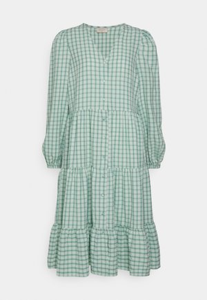 Vestido xadrez verde com mangas compridas, bainha em camadas, decote em V e fechos com botões na parte da frente. Feito de um tecido leve com uma textura suave.