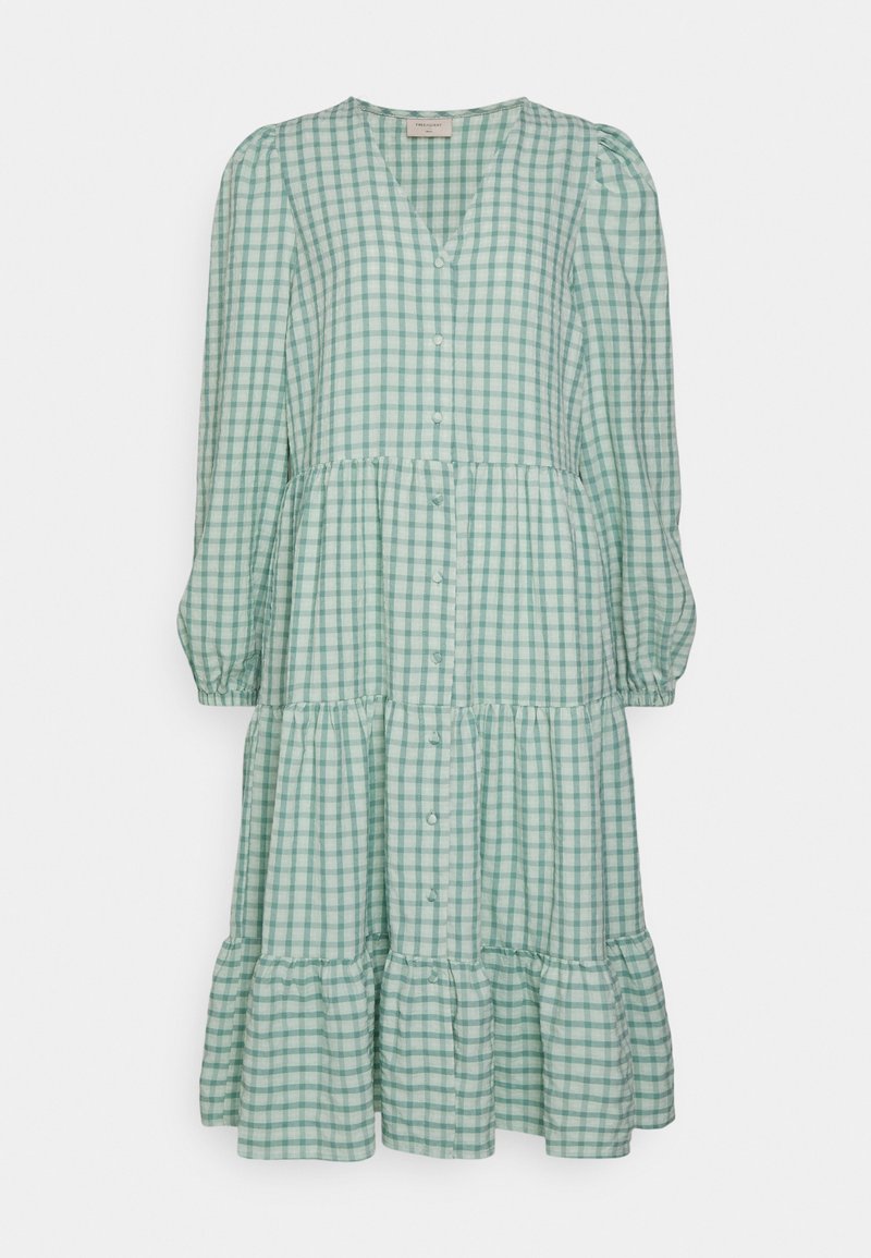 Vestido xadrez verde com mangas compridas, bainha em camadas, decote em V e fechos com botões na parte da frente. Feito de um tecido leve com uma textura suave.