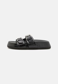 Svarte sandaler i krokodille-embossed skinn med to justerbare spennebånd, flat såle og teksturert overflate for godt grep.
