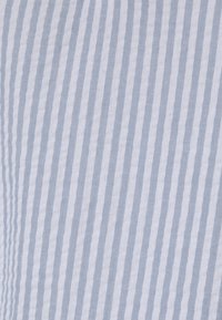 Ljust blå och vita vertikala ränder på en texturerad tygbakgrund.