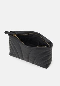 Borsa a pochette in pelle nera con texture trapuntata, chiusura con cerniera dorata e un manico singolo. L'interno è foderato in nero con il logo del marchio.