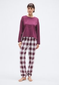 Μπλουζάκι μπορντό με μακριά μανίκια, συνδυασμένο με λευκό και σκούρο μπορντό πικέ παντελόνι πυτζάμας. Μαλακό ύφασμα με ελαστική μέση.