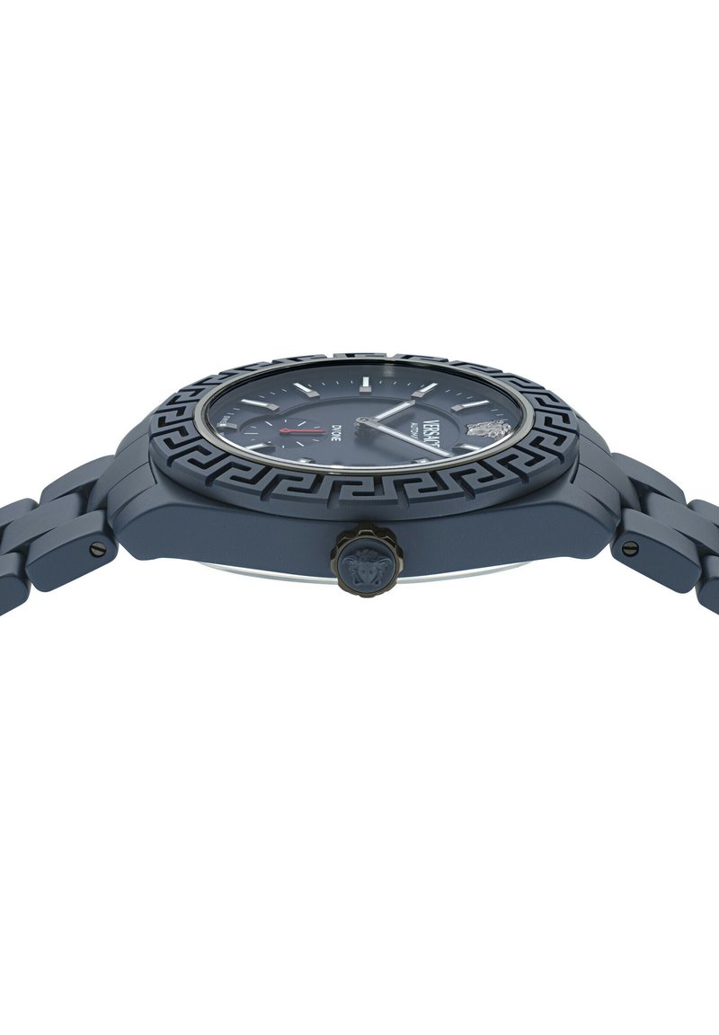  ronde horloge met een blauwe matte afwerking, een gemusterde rand, zilveren accenten en een gedetailleerde kroon. Heeft een donkere wijzerplaat met witte indexen en sub-dials.