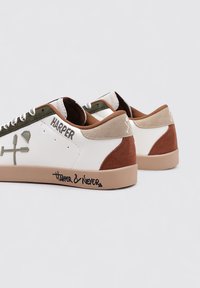 Zapatilla blanca con acentos en ante marrón, panel de cuero verde y suela de goma marrón. Presenta el texto "HARPER" y "HARPER & NEVER" impresos en los costados.