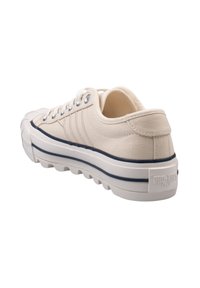 Baskets en toile beige avec un dessus texturé, semelle en caoutchouc blanc et accents rayés bleus. Comprend des œillets en métal et une étiquette de talon avec logo.