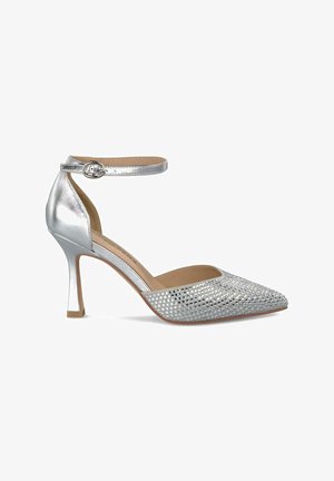 Scarpa con tacco alto argento, dalla punta affusolata, finitura metallica, cinturino alla caviglia e parte superiore testurizzata con piccoli motivi ritagliati.