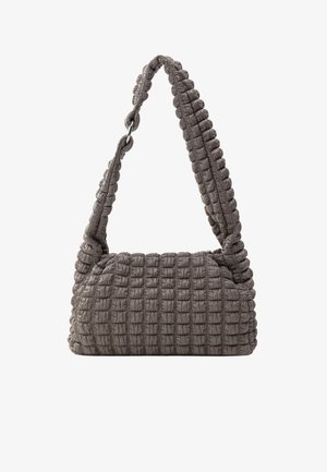Sac à main matelassé gris avec une texture douce et rembourrée ; possède une sangle épaisse et tressée ainsi qu'une forme arrondie, conçu pour être porté à l'épaule.