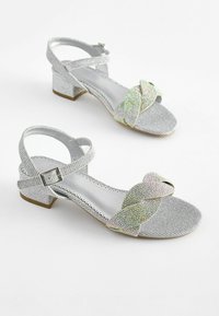 Zilveren enkelband sandalen met een textuur bovenwerk, kleine blokhak en een strikdetail versierd met iriserende rhinestones.